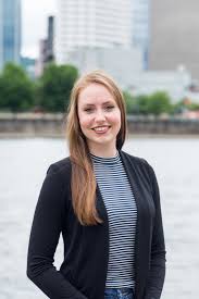 Female realtor headshot near body of water