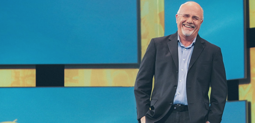 Middle aged man laughing while giving a talk.